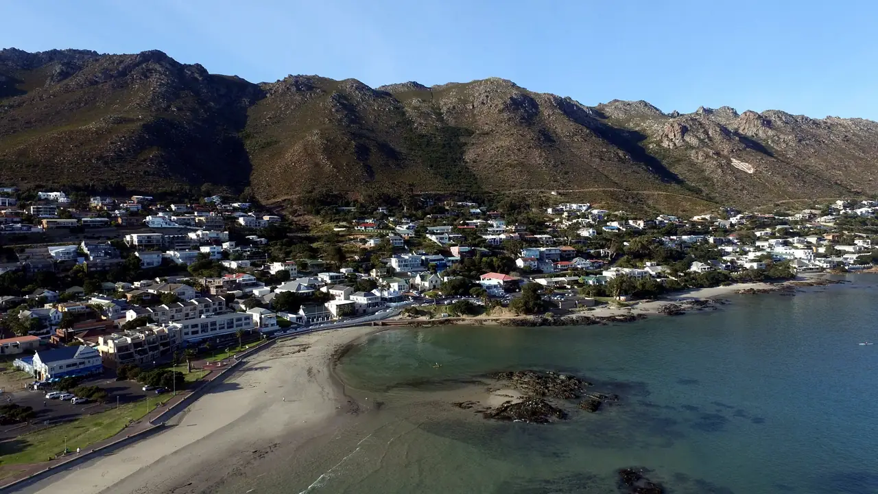 Aerial view of a sandy beach, clear turquoise water and mountains